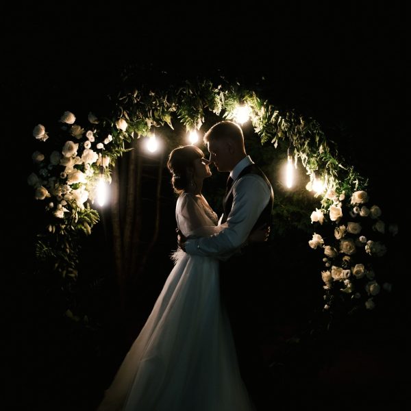 wedding-day-bride-groom-night-vows-near-arch-with-lights-background-fireworks (1) (1)